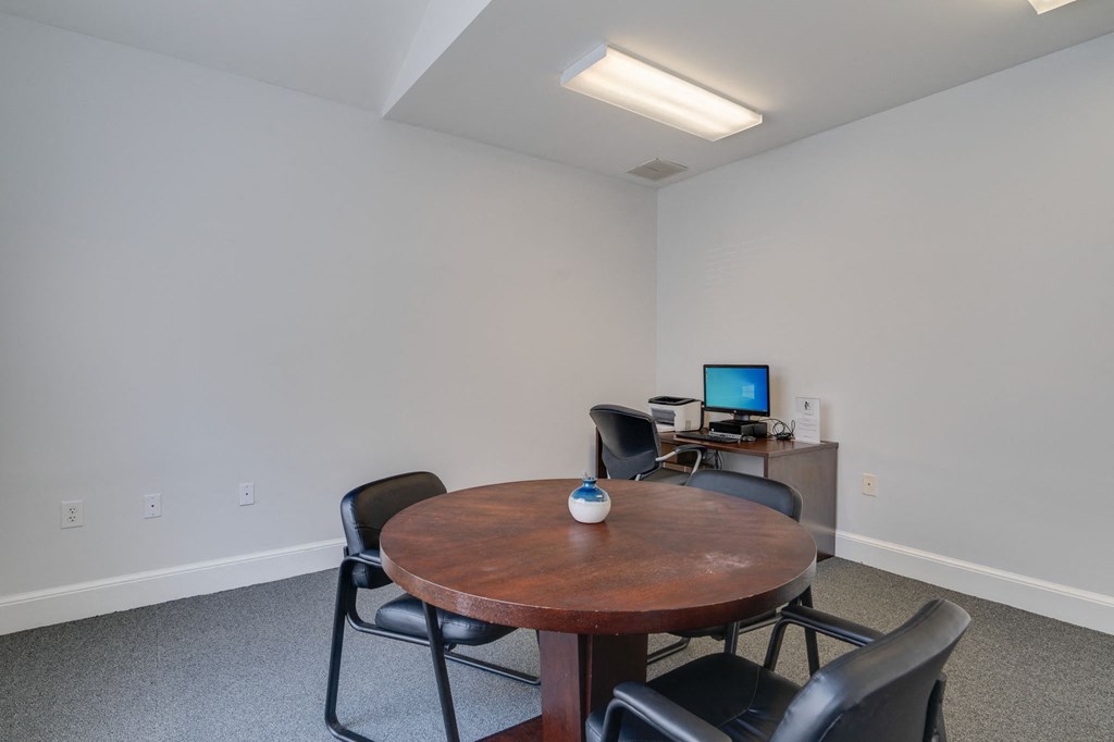 a dining room with a table and chairs and a computer on a desk