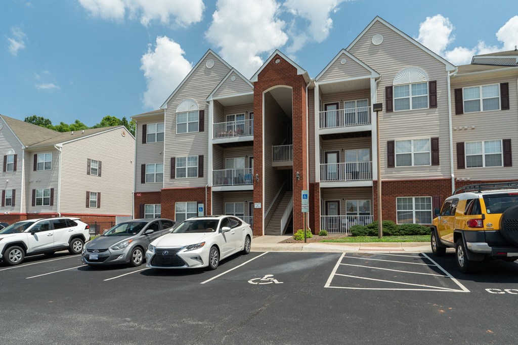 an apartment building with cars parked in a parking lot