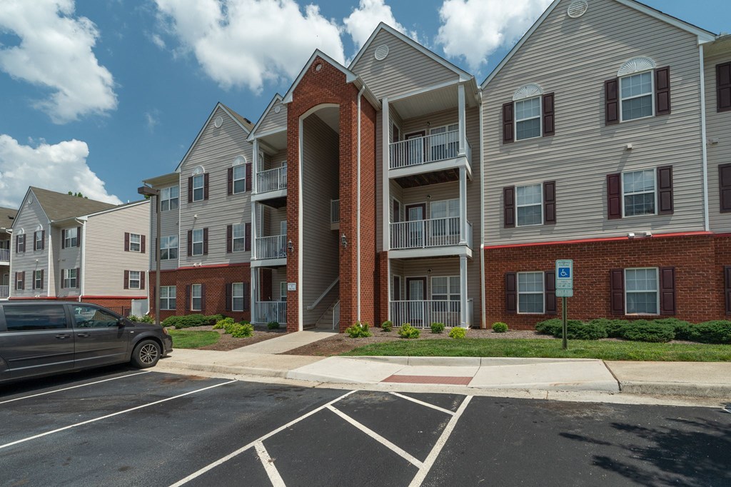 an apartment building with a car parked in a parking lot