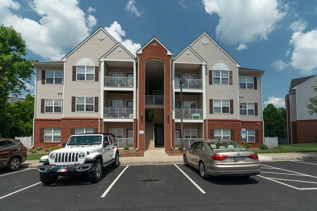 an apartment building with cars parked in front of it