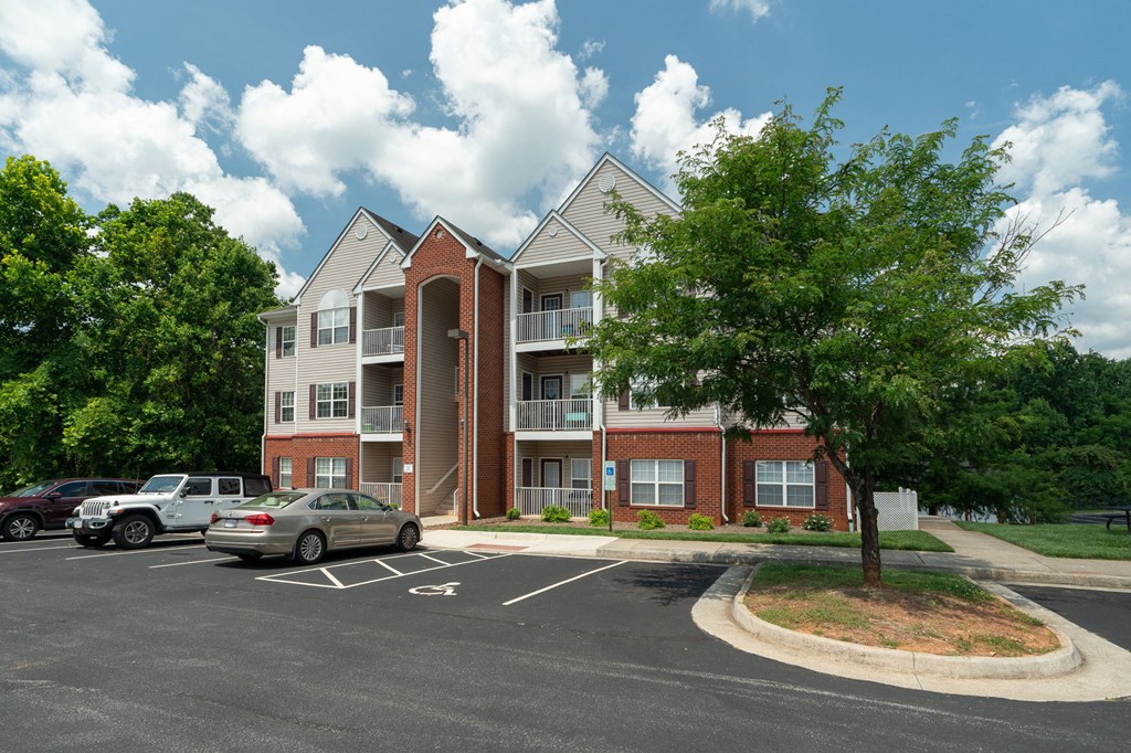 an apartment building with cars parked in a parking lot