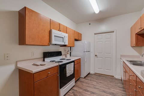 a kitchen with wooden cabinets and white appliances and a white refrigerator