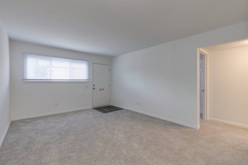 a bedroom with white walls and a window and a door