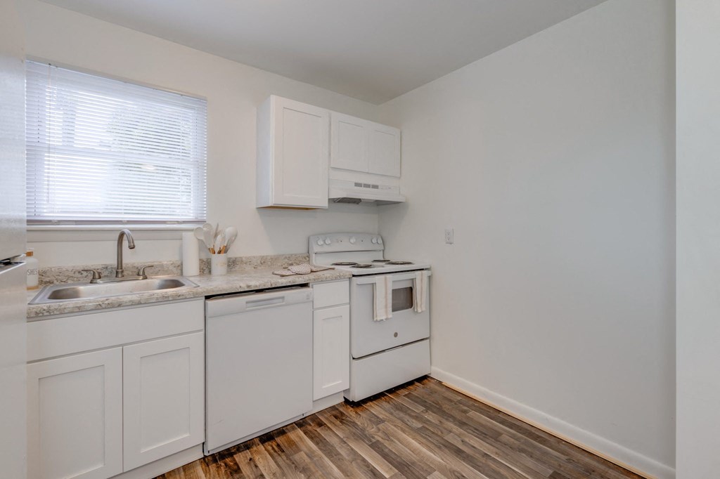 a kitchen with white appliances and a window