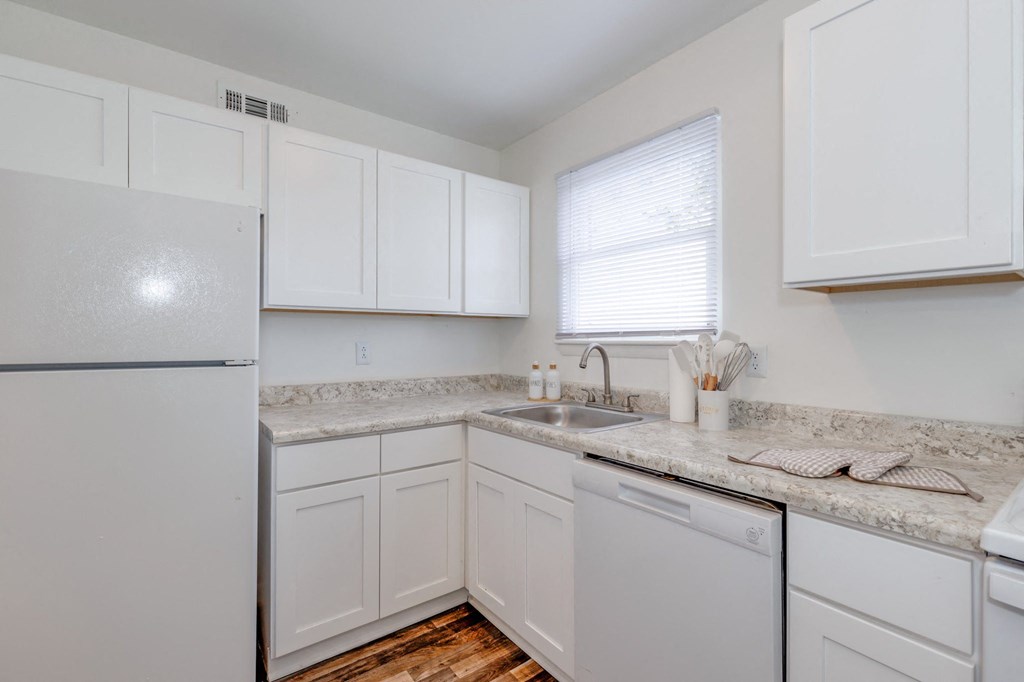 a kitchen with white cabinets and a sink and a refrigerator