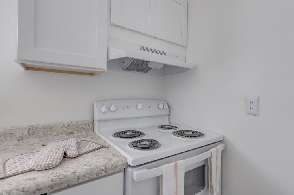 a kitchen with a stove and a counter with a sink