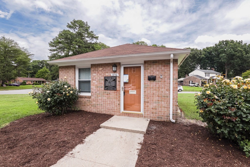 a small brick building with a door and a sign on the side of it