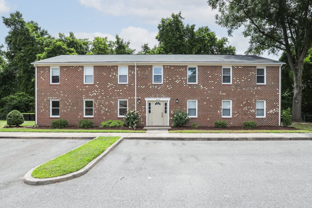 the front of a brick building with a white door