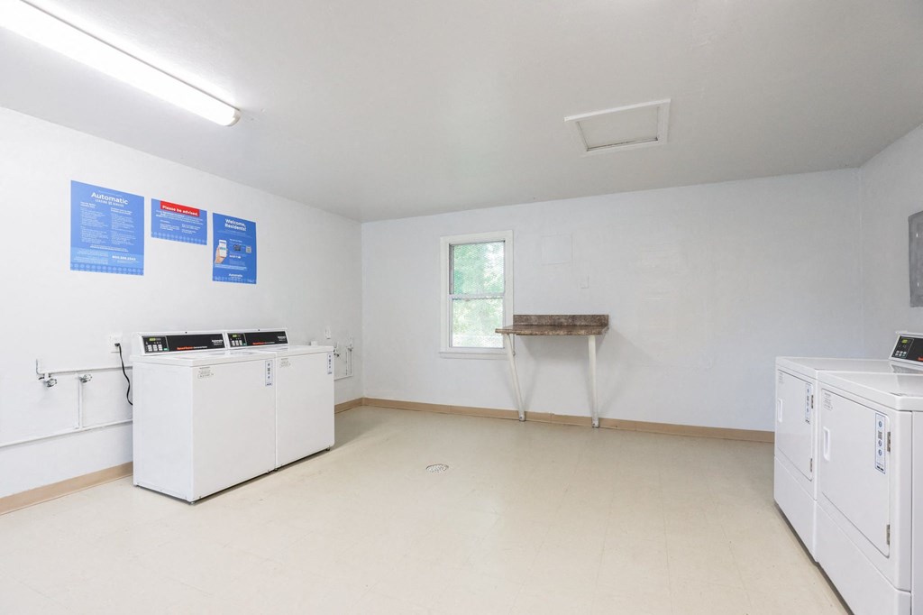 an empty room with white appliances and a window