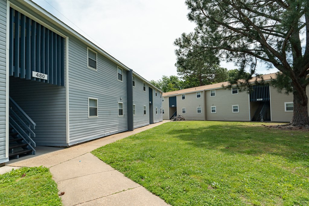 an image of the exterior of a building with a lawn and sidewalk