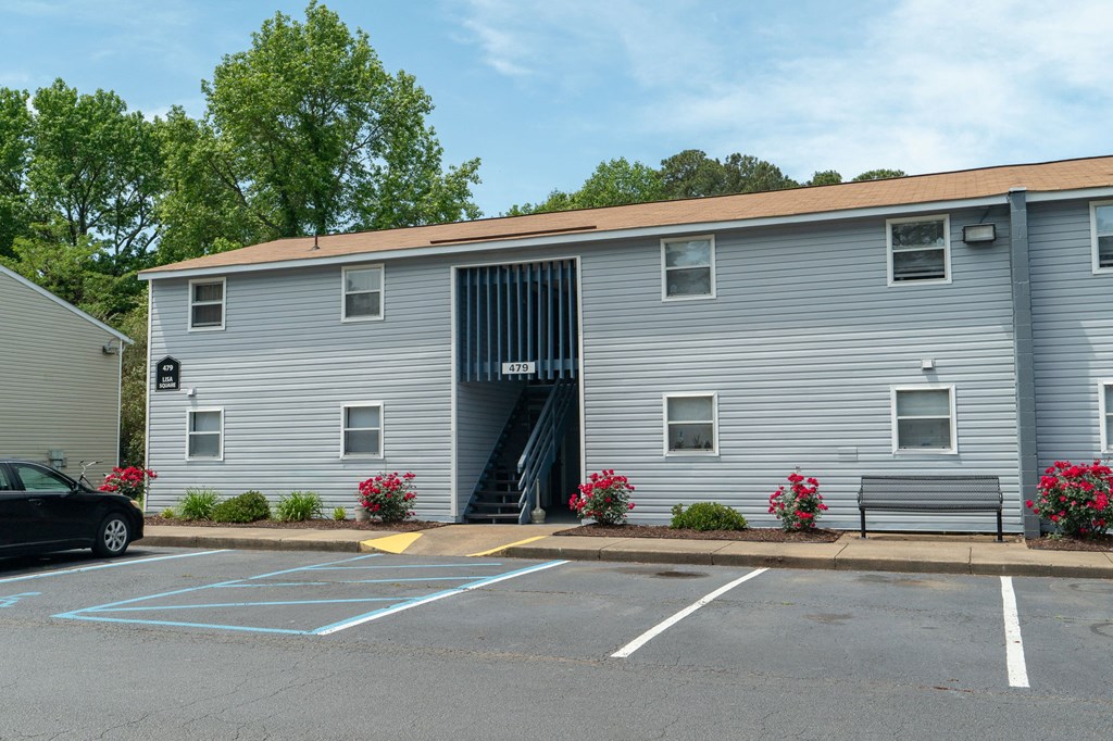 the side of a building with a parking lot and benches