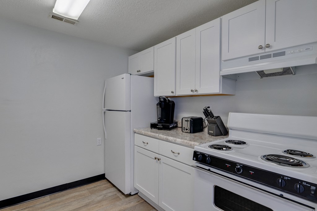 a kitchen with white appliances and white cabinets and a white refrigerator