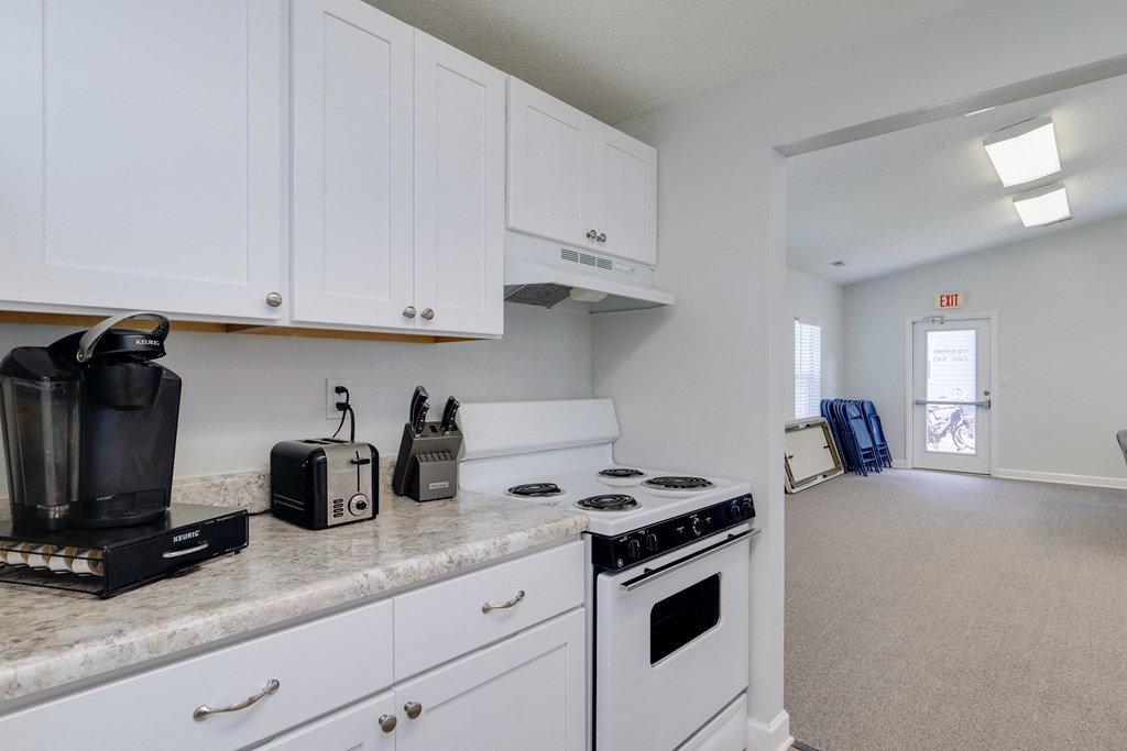 a kitchen with white appliances and white cabinets and a counter top