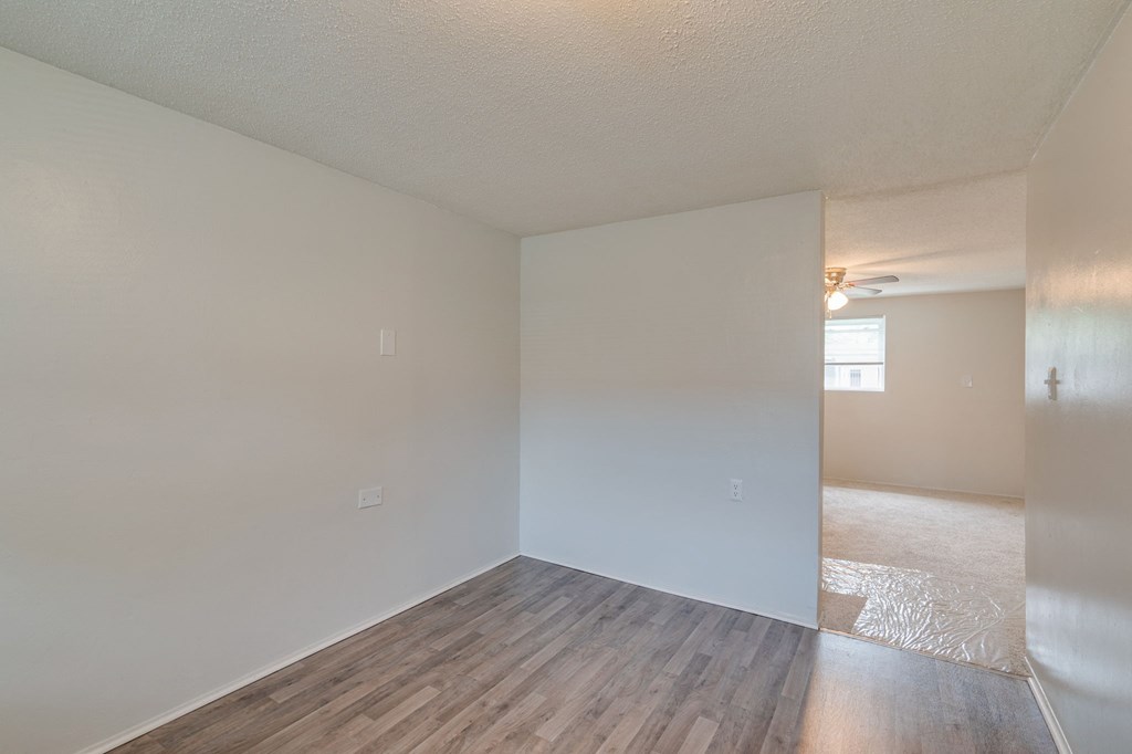 the living room and dining room of an empty apartment