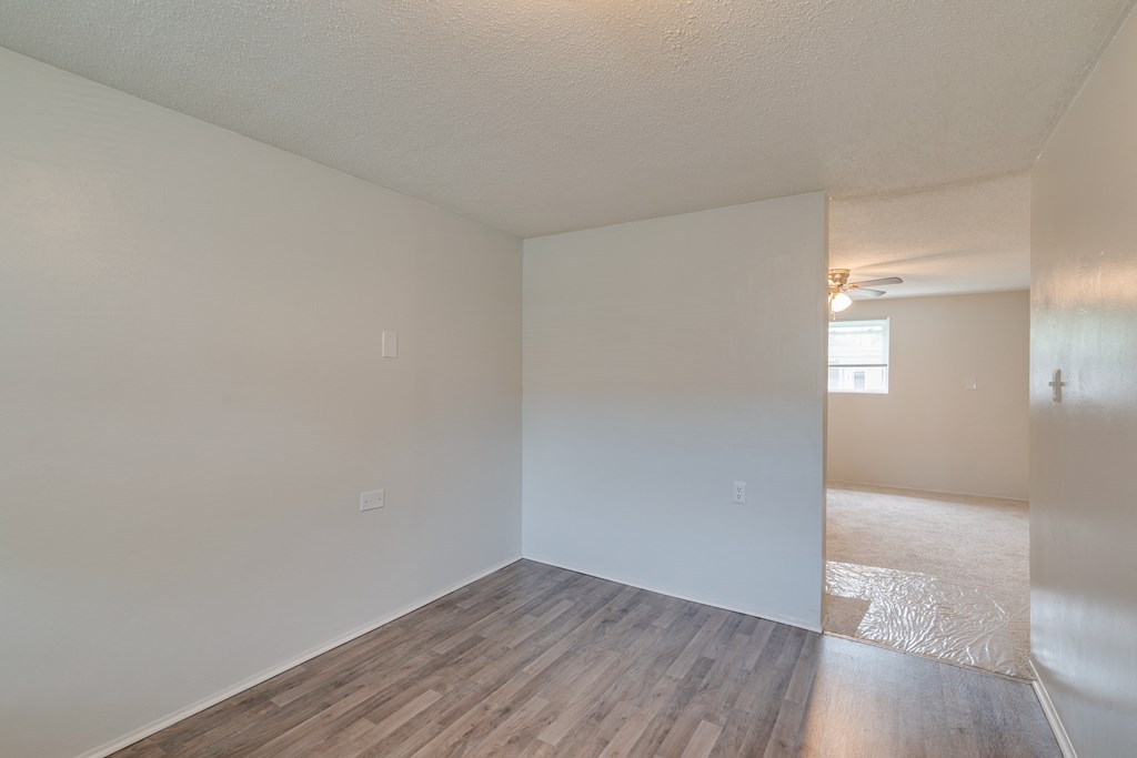 an empty room with a hard wood floor and white walls