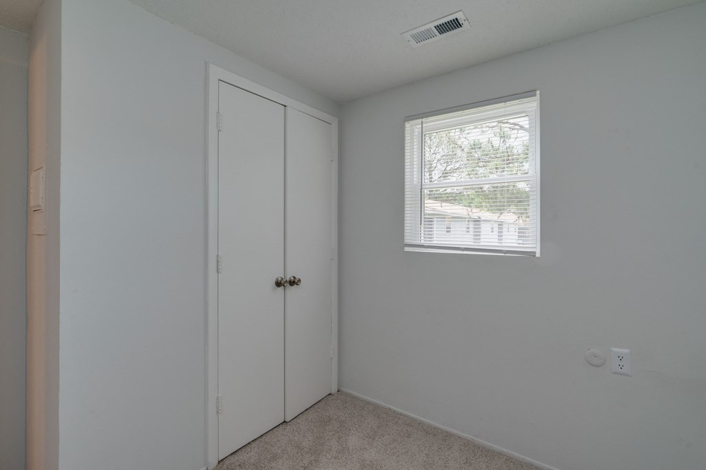 an empty room with a door and a window