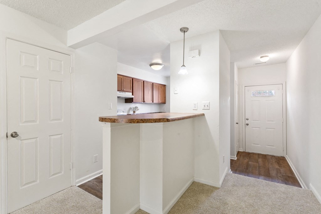 a kitchen with an island and a door to a hallway