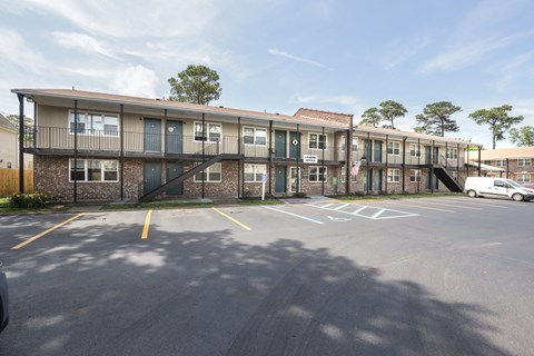 an exterior view of an apartment building with a parking lot