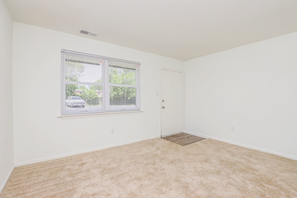a bedroom with a large window and white walls