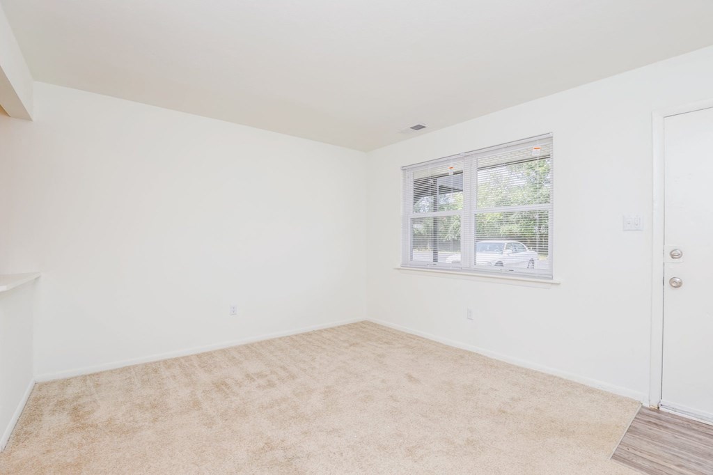 a bedroom with a large window and white walls