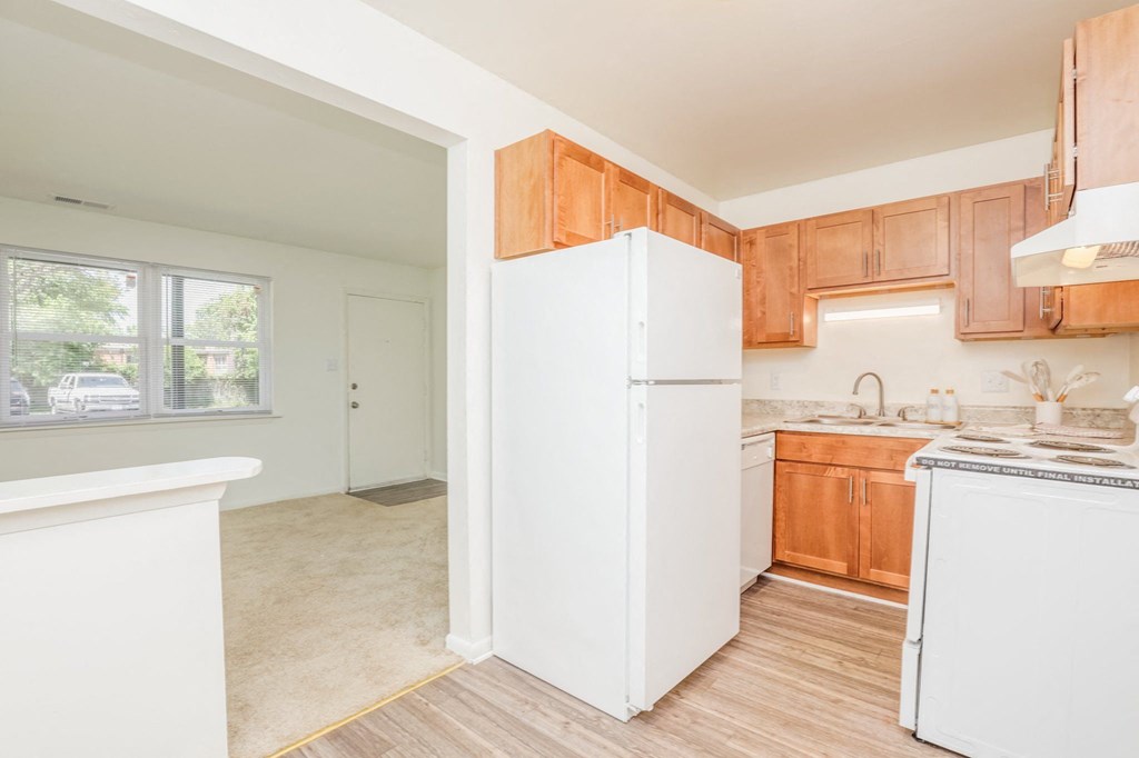 a kitchen with a white refrigerator and wooden cabinets