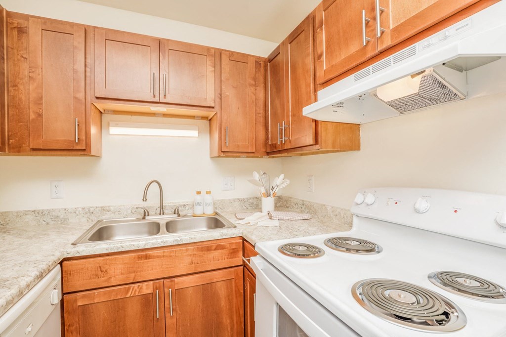a kitchen with white appliances and wooden cabinets