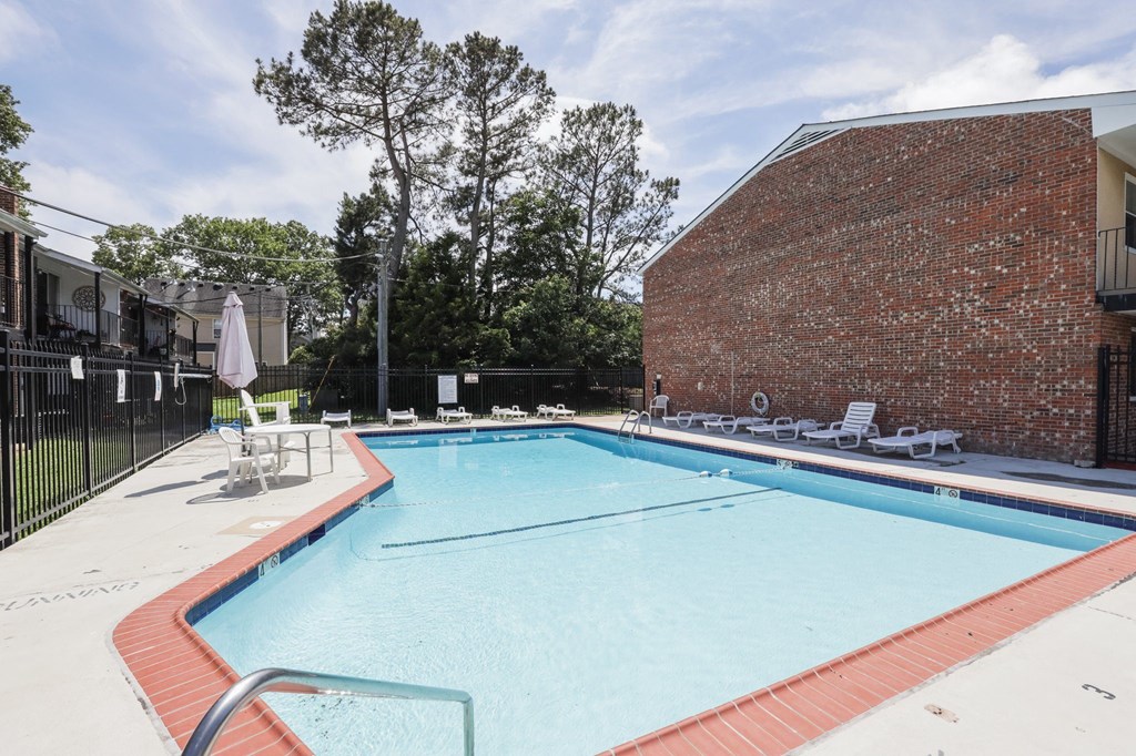 a swimming pool with a brick building in the background