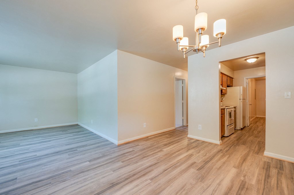 a living room with wood flooring and a kitchen