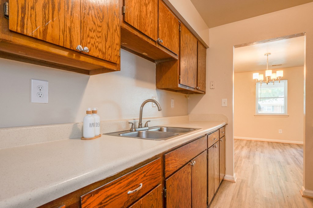 an empty kitchen with wooden cabinets and a sink