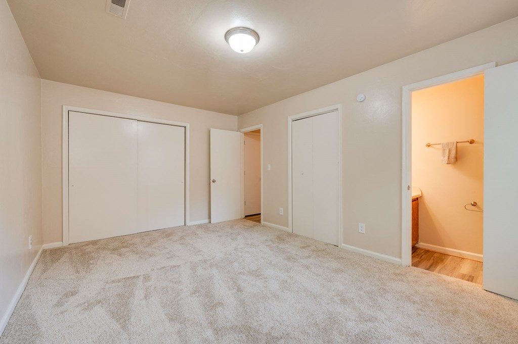 a bedroom with a closet and a door to a bathroom