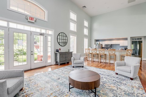 a living room with two chairs and a coffee table and a kitchen in the background