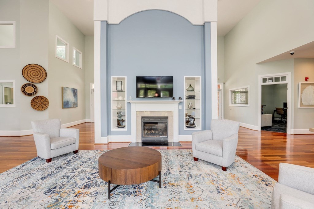a living room with a fireplace and two chairs and a table