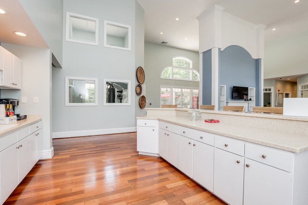 a large kitchen with white cabinets and a wood floor