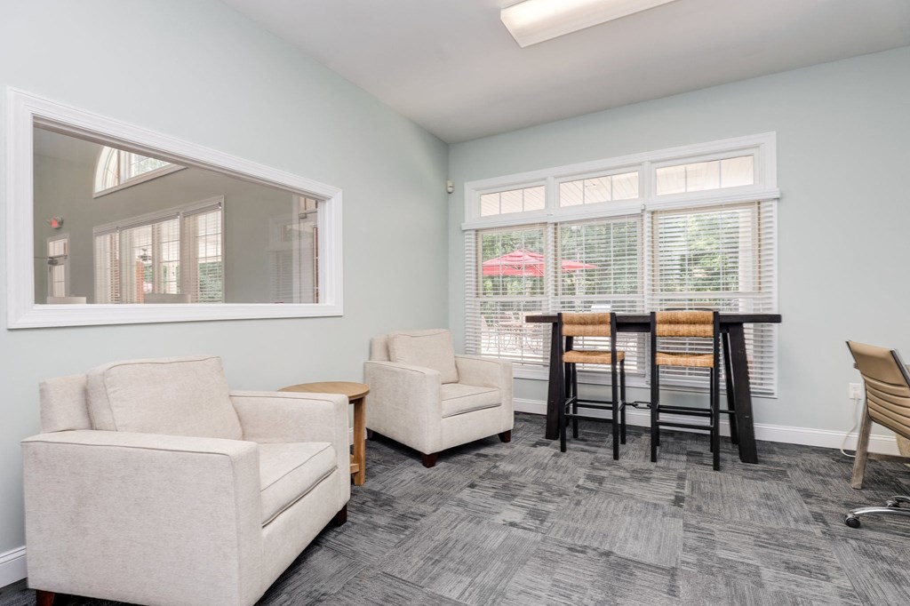 a living room with a dining table and chairs and a large window