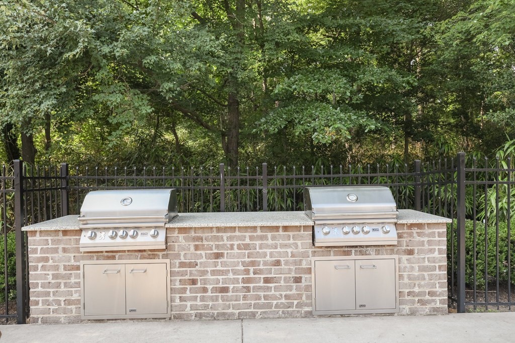 a brick barbecue with two grills on top of it