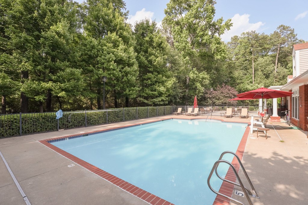 a swimming pool in a backyard with a house and trees