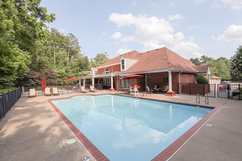 a swimming pool in front of a house with a resort style pool