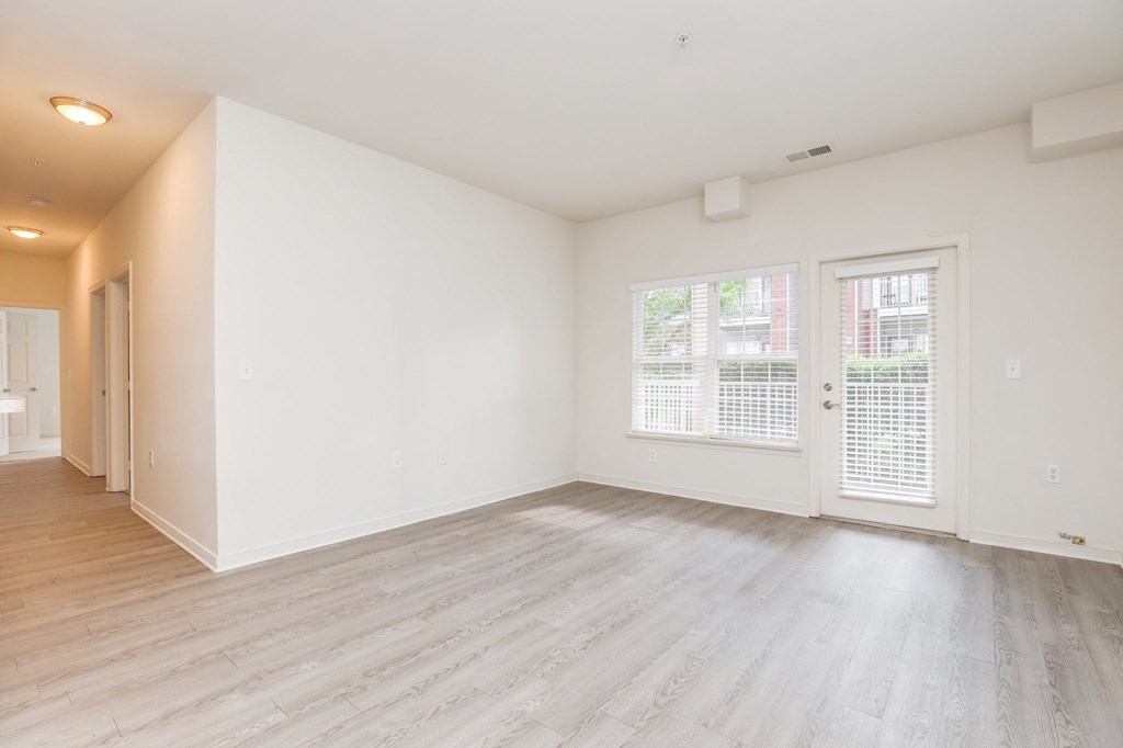 an empty living room with white walls and wood flooring