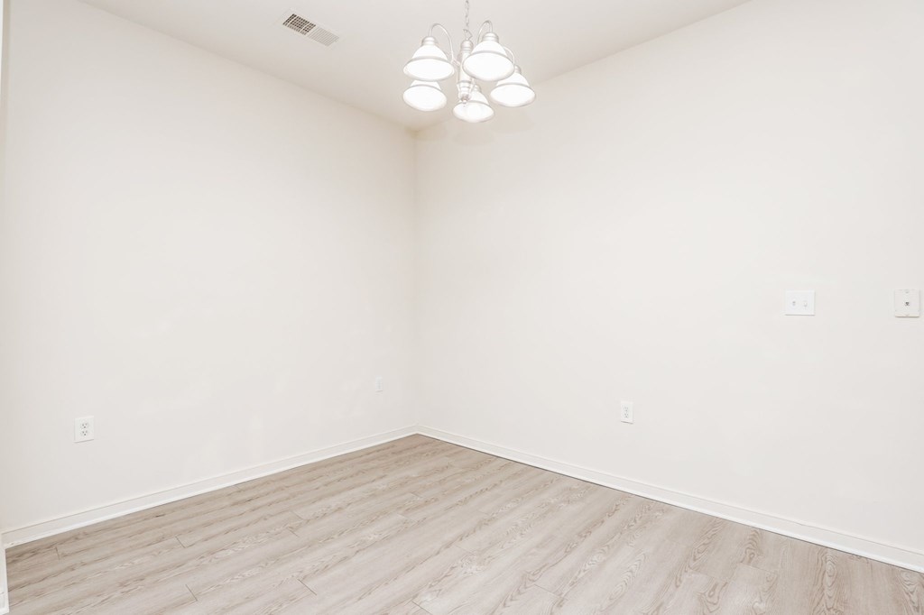 an empty room with wood floors and white walls
