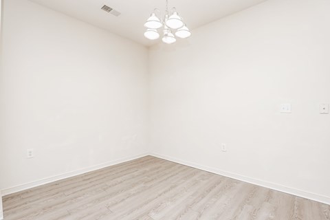 an empty room with wood floors and white walls