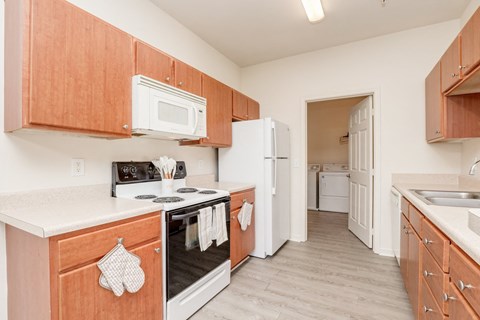 a kitchen with wood cabinets and white appliances and a white refrigerator