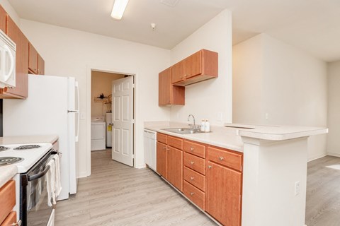 a kitchen with wood cabinets and white counter tops and a white refrigerator