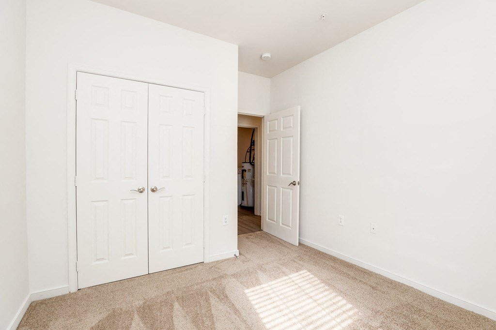 a bedroom with two closets and a door to a hallway