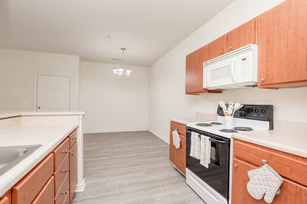 a kitchen with wood cabinets and white appliances and a microwave
