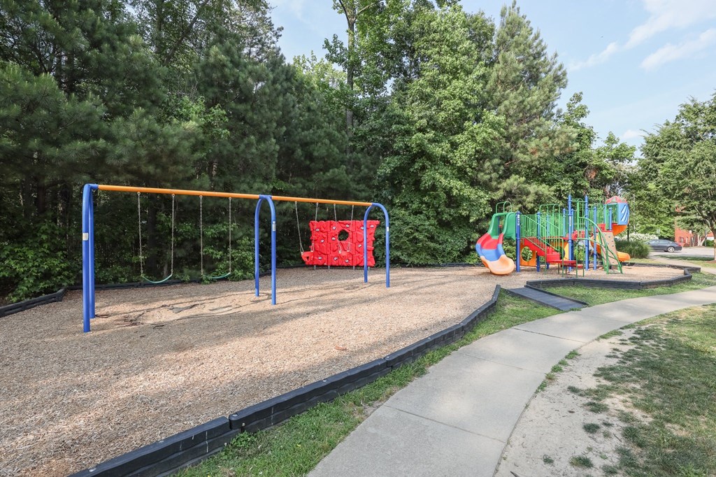 a playground with a swing set and other toys in a park