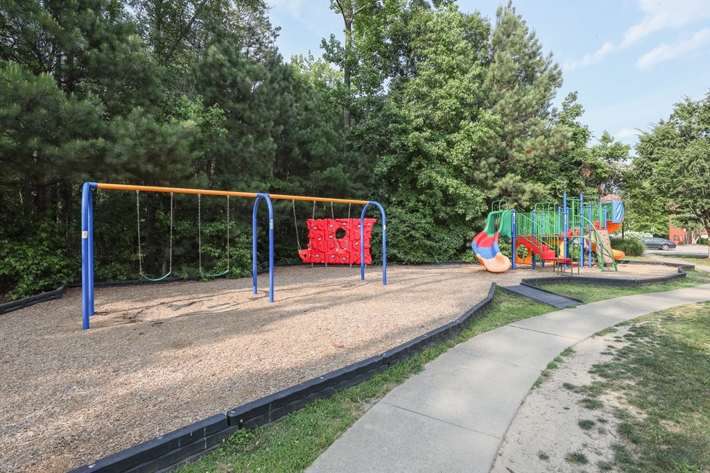 a playground with a swing set and other toys in a park