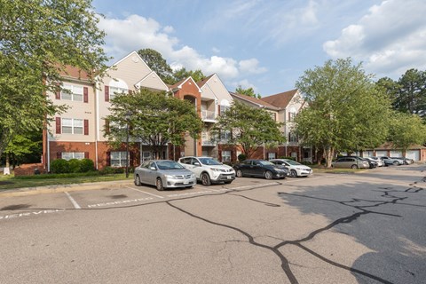 a street with cars parked in front of apartment buildings