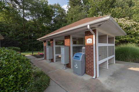 a small building with two trash cans in front of it