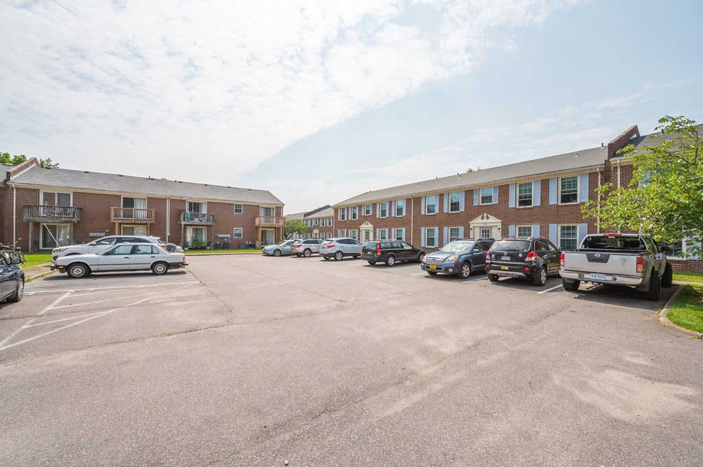 a parking lot with cars in front of an apartment building