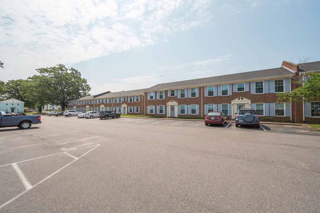 a large parking lot with cars in front of a building
